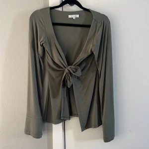 Grön topp från Design by Si - Grön topp från Design by Si med knytning framtill. Helt oanvänd! 399kr på deras hemsida.