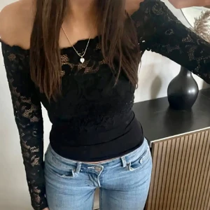 Svart offshoulder spetstopp - ❕Återförsäljning första bilden inte min❕sjukt snygg svart offshoulder topp i spetsmaterial. Perfekt för en kväll ute eller en snygg vardags look. Toppen har långa ärmar och en tight passform som framhäver figuren. På första bilden är det ett linne under. Förra säljaren: @HHsellout  💕🫶