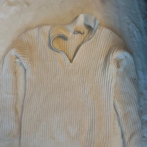 Vit stickad tröja från NA-KD - Säljer en superfin vit stickad halvzip- tröja från NA-KD. Perfekt för kyliga dagar när du vill vara både varm och stilren. Passar till både jeans och kjol! Passar xs/s