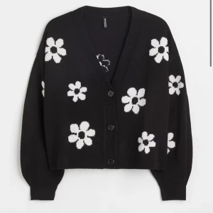 Svart kofta med vita blommor - Säljer en superfin svart kofta från h&m med vita blommor över hela. Den har en v-ringad design och knappar framtill. Perfekt för både höst och vår när du vill ha något mysigt men ändå stilrent. Koftan är i bra skick. Nypris 300kr 🖤