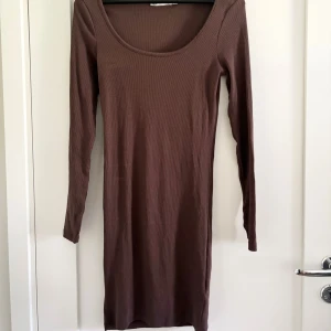 Brun ribbad klänning från 157 - Säljer en snygg brun ribbad klänning från Lager 157 i storlek S. Klänningen har en tight passform och långa ärmar, perfekt för höst och vinter. Passar både till vardags och fest!