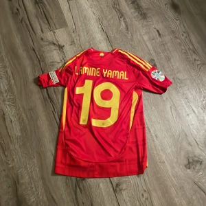 Lamine Yamal - Röd snygg spanien tröja em 2024 på wonder boyen från barca lamine yamal. Säljer då jag hejar på real och inte använder den. använd fåtal gånger