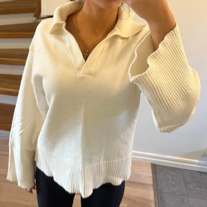 Vit stickad tröja med krage - Säljer en superfin vit stickad tröja med en snygg krage och v-ringning. Den har långa ärmar och ribbade detaljer vid ärmslut och nederkant. Perfekt för både höst och vår, och den är i nyskick! 🧶✨