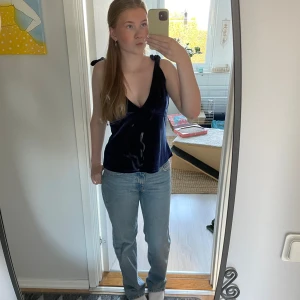 Mörkblå sammetstopp från NA-KD - Säljer en superfin mörkblå sammetstopp från NA-KD. Den har en djup v-ringning och knytband på axlarna. Perfekt för en festkväll eller en utekväll med vänner. Toppen är i storlek M och sitter bekvämt. Aldrig använd!