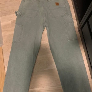Carhartt double knee jeans - Säljer ett par gröna byxor från Carhartt i storlek 32x30. De har knappast använts och har en loose fit, perfekt för en avslappnad look. Vid snabb affär 350 kr!