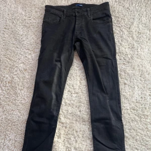 Svarta Gstar jeans - Säljer nu ett par snygga svarta jeans från märket Gstar. De är i utmärkt skick och har storleken W32 L34.  Hör av er vid minsta intresse! Priset inte hugget i sten.