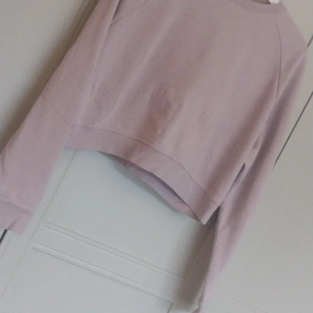 Säljer en superfin ljusrosa croppad sweatshirt. Den är perfekt för en avslappnad stil och har långa ärmar. Materialet känns mjukt och skönt, perfekt för både vår och höst. Passar perfekt till ett par jeans eller leggings! Märket DRI-FIT strl M. Sportswear.