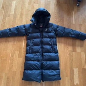 Haglöfs Dunjacka  - Haglöfs , Long Down Parka Women Jättefin och varm jacka från Haglöfs. Köpt förra året, och använd under den vintern. Väldigt bra skick, inga defekter! Storlek: Women XS Nypris: 4200 kr