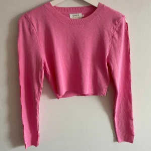 Rosa croppad tröja från ONLY - Säljer en superfin rosa croppad tröja från ONLY. Den är långärmad och har coola utskärningar längs ärmarna som ger en unik look 💖