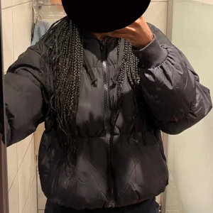 Vinter Jacka - Säljer en svart pufferjacka från H&M Divided. Den är bra för kalla dagar, jackan har långa ärmar och en skön huva. Den är i bra skick och passar perfekt för både höst och vinter, den har någon smink fläck på framsidan som inte alls syns. Nypris: 300