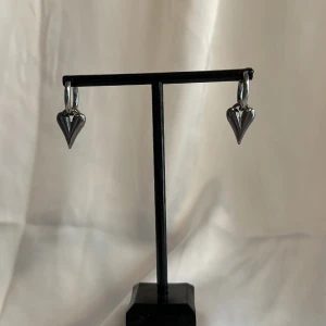 Silvriga örhängen - Egentillverkade silvriga örhängen med silver berlocker i form av hjärtan