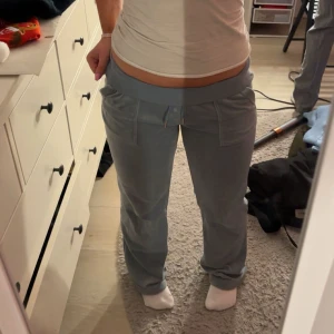 Blå mjukisbyxor - Säljer ett par bekväma blå jucybyxor med låg midja och snörning i midjan. Perfekta för en avslappnad stil. Skicket är bra. Lite söndertrampade längst ner men de är inget man tänker på 