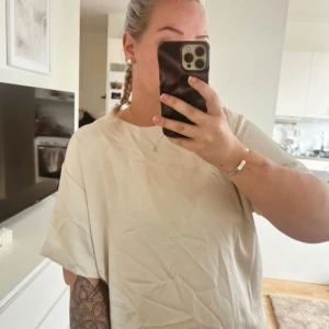 Snygg satin t-shirt - Helt ny (endast provad) beige t-shirt i satin med dragkedja baktill. 