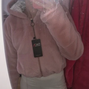 Rosa teddyjacka med luva - Mysig rosa teddyjacka från Syrien med dragkedja och huva. Helt ny med prislapp. Jackan har en fluffig textur och en avslappnad passform