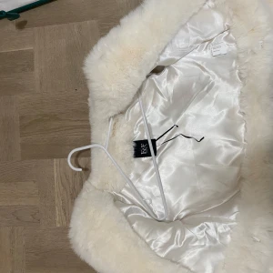 Vit pälsjacka från R.E.D. - Säljer en fluffig och stilren vit pälsjacka från F&F. Jackan har en mjuk och lyxig känsla med långärmad design. Aldrig använd 