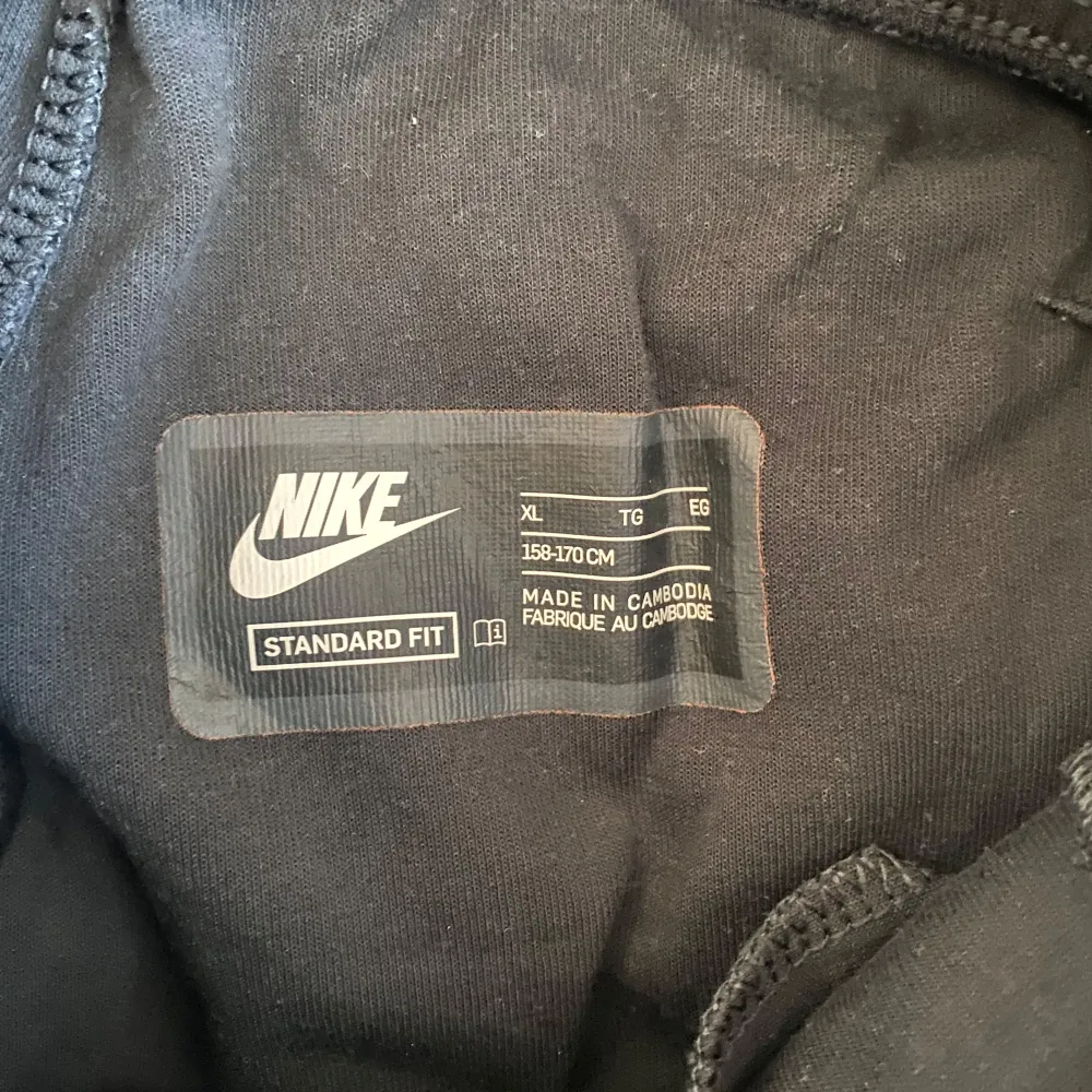 Säljer ett svart träningsset från Nike i standard passform. Setet består av en långärmad tröja med dragkedja och matchande byxor. Perfekt för träning eller en avslappnad dag.. Neuletakit & Villapaidat.