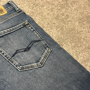 Blå jeans från Replay - Snygga blå jeans från Replay med klassisk femficksdesign och knappgylf. Perfekta för en avslappnad stil med en straight passform.