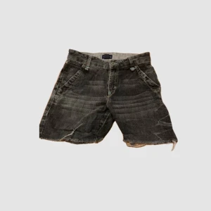 Svarta jeansshorts - Säljer ett par blå/svarta vintage shorts med snygga detaljer
