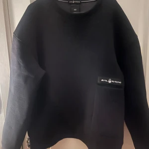 Svart tröja från Sail Racing - Säljer en stilren svart tröja från Sail Racing i storlek L. Tröjan har en enkel design med en diskret logga på bröstet. Inte alls mycket använd och är i väldigt bra skick. Priset kan gå att diskuteras! 