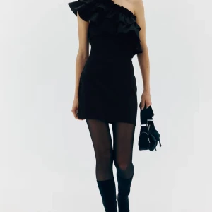 Svart oneshoulder klänning med volang - Super snygg svart oneshoulder klänning med volang. Helt ny med prislapp kvar, endast testad. Helt slutsåld nästan överallt. Kan fixa egna bilder om det önskas! Sitter även lika snyggt om man har stl S🥰säljer då jag har köpt två