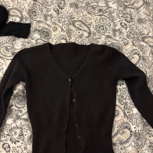 Cardigan/Knapp Topp - En cardigan eller topp med knappar, tajt sittande, Slutar under naveln💘