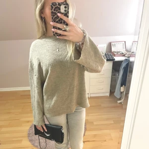 Beige stickad tröja - Mysig beige stickad tröja med långärmad design. Perfekt för kyligare dagar med en avslappnad passform. Enkel och stilren, passar till många olika outfits.