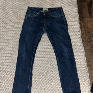 Acne Studios jeans - Snygga blå jeans från Acne Studios i modellen ROC RAW. Klassisk design med fem fickor och knappgylf. Perfekta för en stilren look.