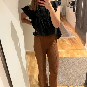 Bruna byxor - Snygga bruna byxor med hög midja och en rak passform. Perfekta för en stilren look med en skön känsla. Byxorna har en klassisk design som passar till många olika tillfällen.