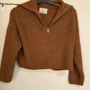 Brun stickad tröja från Zara - Mysig brun stickad tröja från Zara med dragkedja framtill. Tröjan har en bred krage och långa ärmar. Aldrig använd. Storlek 152 men jag brukar ha xs-s i tröjor och den passar jättebra. Skriv om ni vill ha fler bilder så löser jag det💖