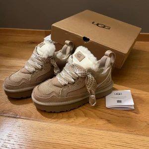 Beige sneakers från UGG  - Säljer ett par snygga beige sneakers från UGG med fluffigt foder och breda snören. Skorna är i färgen ”Sand” och är i storlek 37, men små i storleken. Dom är i topp skick eftersom de är nya och oanvända, bara testade. Skriv vid frågor och funderingar! 💓💓