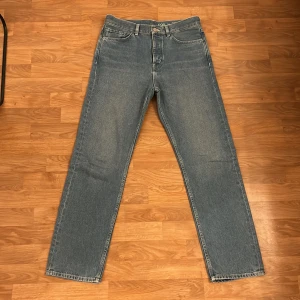 Blå jeans från COS - Säljer ett par klassiska blå jeans från COS med rak passform. De har en midwaist och är tillverkade i ett slitstarkt denimtyg. Perfekta för en stilren look. Inga fläckar eller slitage. Skriv gärna om ni har frågor allt ifrån pris till fler bilder. 