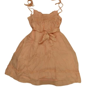 Rosa söt klänning - Den sista bilden representanter färgen i verkligheten bäst. Många rosetter så den går att justera mycket. Inga defekter. 63cm lång mätt från längst ner på v-ringen till slutet på klänningen. 100%silk