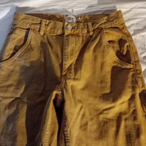 Gula cargobyxor från 157  - Säljer ett par gula cargobyxor från 157. Byxorna har en loose passform med flera praktiska fickor och en hög midja. Perfekta för en avslappnad stil.