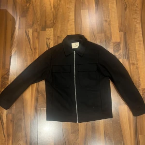 Svart jacka från Jack & Jones - Säljer en stilren svart jacka från Jack & Jones i mycket bra skick. Har knappt använt jackan då det har blivit kallt väder. Original pris ligger på 1000, säljer för 800 kr (Priset kan diskuteras)