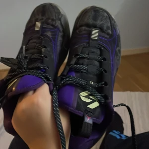 Lite smutsiga använda 3 år - Säljer ett par coola sneakers i svart och lila med turkosa detaljer. Skorna har snörning och en unik design med stänk av turkos på sidorna. Perfekta för både vardag och träning. De är i bra skick och redo för nya äventyr! Non exieris 77 luka doncic