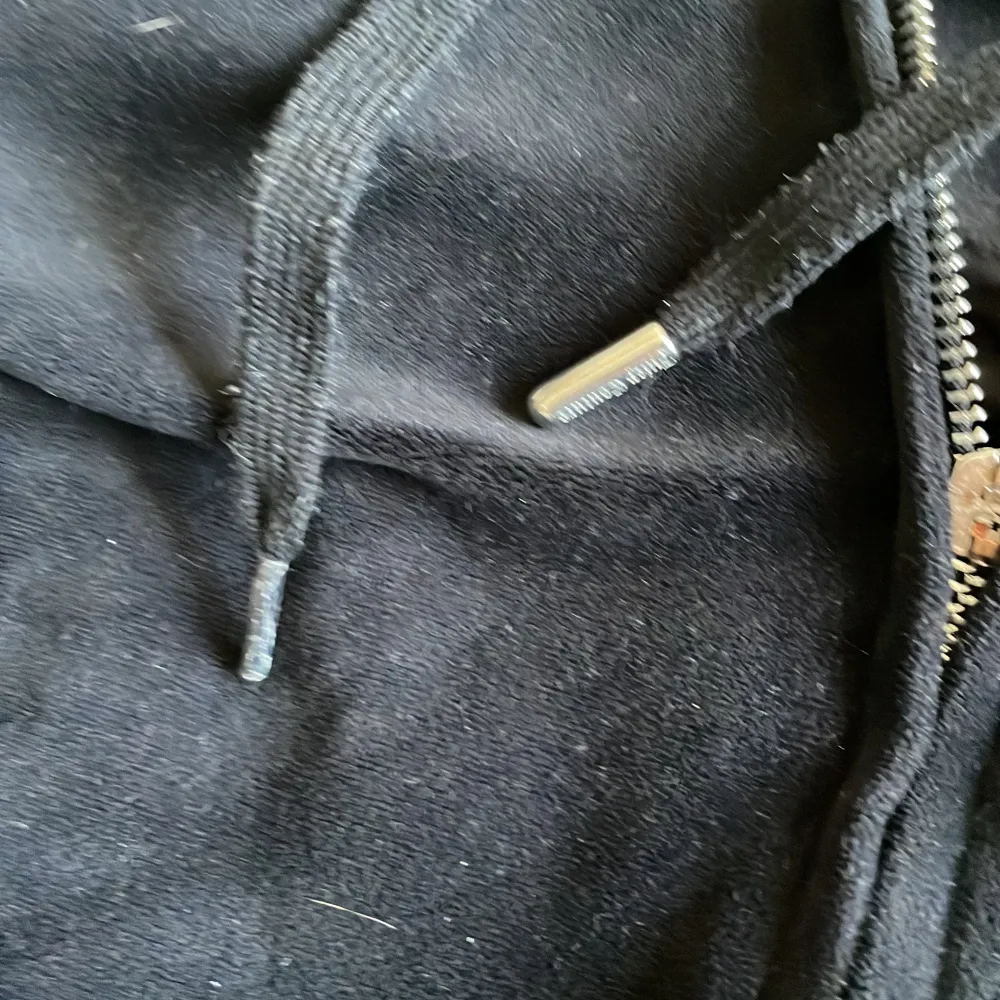 Säljer en svart Juicy Couture hoodie i velour med dragkedja och huva. Den har snygga strassdetaljer på ryggen som bildar texten 'Juicy'. Loggan har saknats sedan jag köpte den ny, en metalsak saknas även på ena bandet, har det hemma dock så kan limma på det. Tröjor & Koftor.