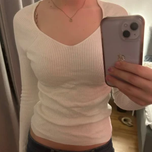 Vit ribbad topp - Säljer en superfin vit ribbad topp från primark med långa ärmar. Den är tight och v-ringad, använd fåtal gånger. Säljer då den aldrig kommer till användning💓