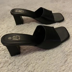 Svarta klackskor från Anna Field - Snygga svarta klackskor från Anna Field i storlek 40. De har en stilren design med öppen tå och bred klack, perfekt för både vardag och fest. Tillverkade i syntetmaterial som ger en elegant look. Passar perfekt till sommarens alla tillfällen!