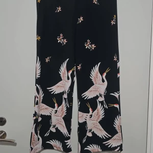 Byxor med mönster  - Svarta med mönster.  Stl M Total längd: 81cm  Fint skick