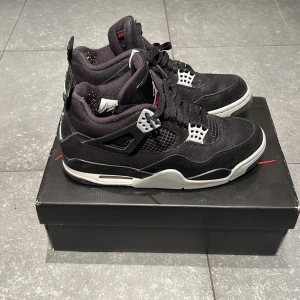 Svarta Air Jordan 4 Retro SE - Säljer ett par snygga Air Jordan 4 Retro SE i svart och grått. Skorna har en cool design med snörning och den klassiska Jumpman-loggan. Perfekta för både vardag och fest! De är i mycket bra skick och kommer i originalkartong.