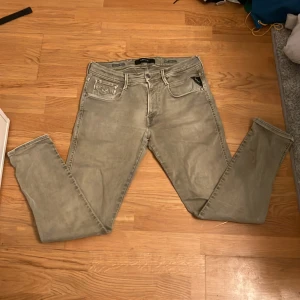 Grå Replay Anbass Hyperflex Jeans - Säljer ett par grå Replay Hyperflex jeans i storlek W32 L30. De är i bra skick och har en snygg, modern look. Perfekta för både vardag och fest. De har en klassisk femficksdesign och en bekväm passform.