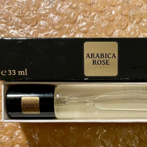 *NY*Arabica Rose Eau de Parfum 33 ml fr NAINA, Presenttips !  - Arabica Rose Eau de Parfum för kvinnor. 33 ml. Ny oanvänd.  Arabica Rose är en lyxig och förförisk doft som utstrålar orientalisk elegans. Den öppnar med rika och djupa noter av ros som omedelbart ger en intensiv och romantisk känsla. Hjärtnoten är varm och kryddig med inslag av saffran, som tillför en exotisk och förfinad touch. Basen är fyllig och sensuell med toner av patchouli, oud och amber, vilket ger en långvarig och sofistikerad avslutning. Ord pris: 200 sek, Pris nu: 70 sek 