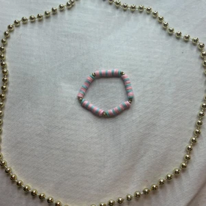 Färgglatt armband  - Säljer ett  färgglatt armband. Armbandet har rosa och turkosa pärlor med små gulddetaljer, perfekt för att liva upp vilken outfit som helst. . Perfekt för sommarens fester eller som en fin present!