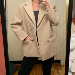 Kort kappa - Beige kort kappa i oversized modell. Det saknas en knapp men jackan går att ha knäppt ändå. Annars sällan använd. 