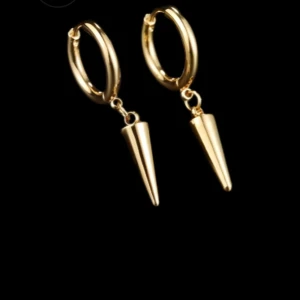 Edblad liknande örhängen - Snygga guldörhängen med coola konformade hängen. Perfekta för att ge din outfit en edgy touch. De är i mycket bra skick och passar både till vardags och fest. Enkla att matcha med andra smycken och accessoarer.