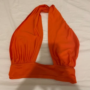 Två halterneck toppar i orange och beige - Två super fina toppar den oranga är helt oanvänd och den beiga är använd några få gånger pris förslaget gäller för en topp vill man köpa båda tillsammans kan priset diskuteras