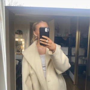 Beige kappa från Noisy May/only - Säljer en superfin beige kappa från Noisy May. Den är i storlek S och har en stilren design med bred krage. Perfekt för höst och vår! Kappan är i mycket bra skick och passar till både vardag och fest. 🧥✨ står strl L i den men sitter mer som en S! 