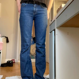 Blå jeans från Gina tricot - Säljer ett par snygga blå jeans från Gina Tricot i storlek 34. De har en klassisk straight passform och är perfekta för både vardag och fest. Jeansen är i mycket bra skick och har en tidlös design som aldrig går ur stil.
