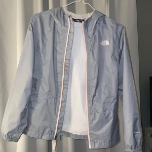 Grå vindjacka från The North Face - Säljer en snygg grå vindjacka från The North Face i storlek xs/s. Jackan har en dragkedja fram och en praktisk huva. Perfekt för vår och höst när vädret är lite ostadigt. Den är i mycket bra skick och redo för nya äventyr! 🌧️pris går att diskuteras