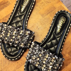 Svarta sandaler med glittriga detaljer - Snygga svarta sandaler från Diresya i storlek 35. De har en quiltad sula och är dekorerade med glittriga pärlor och paljetter på ovansidan. Perfekta för en festlig sommarkväll! 🖤✨